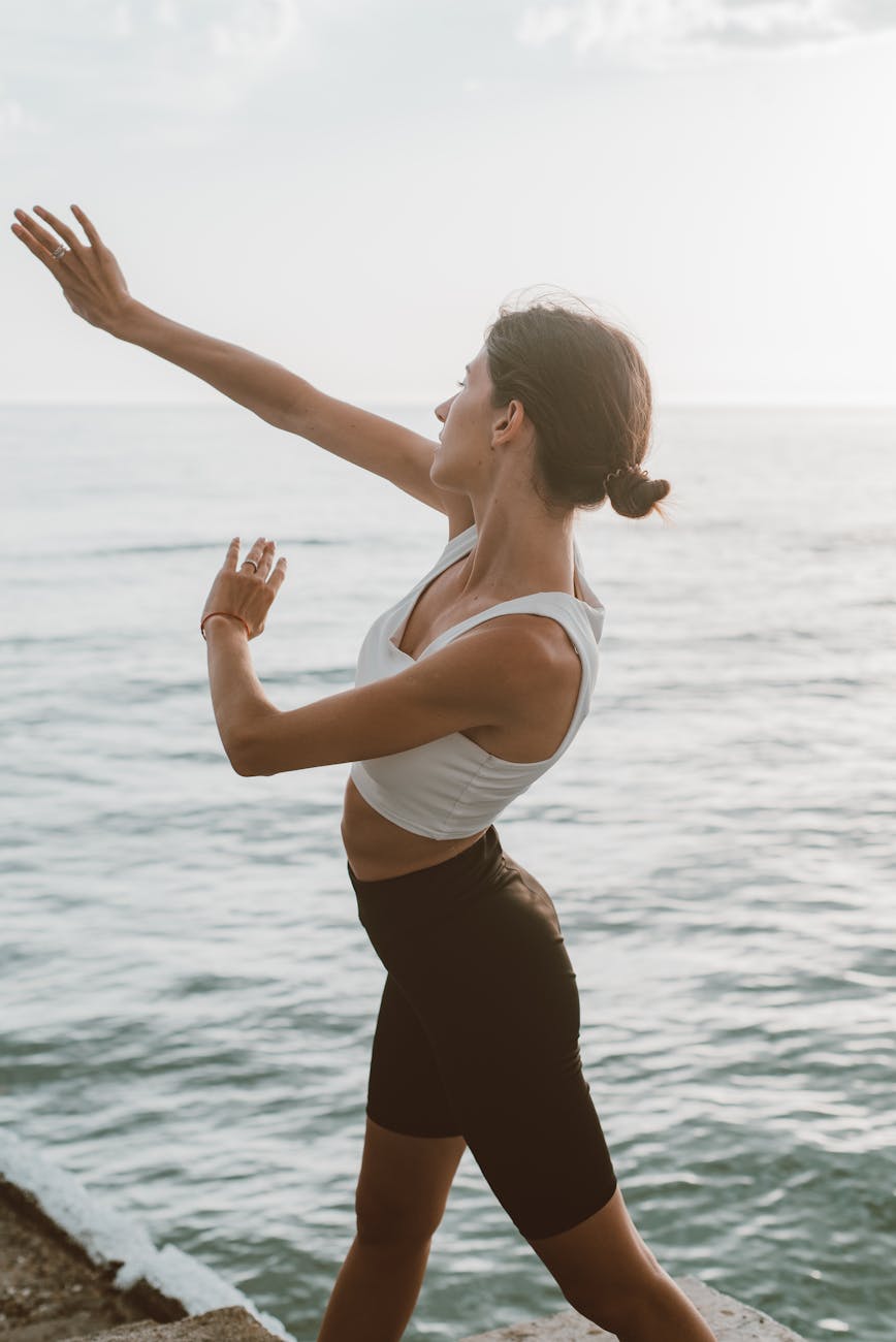 Woman practicing yoga outdoors during a peaceful sunrise